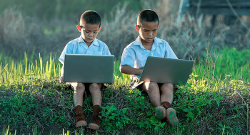 two children playing on gaming laptops